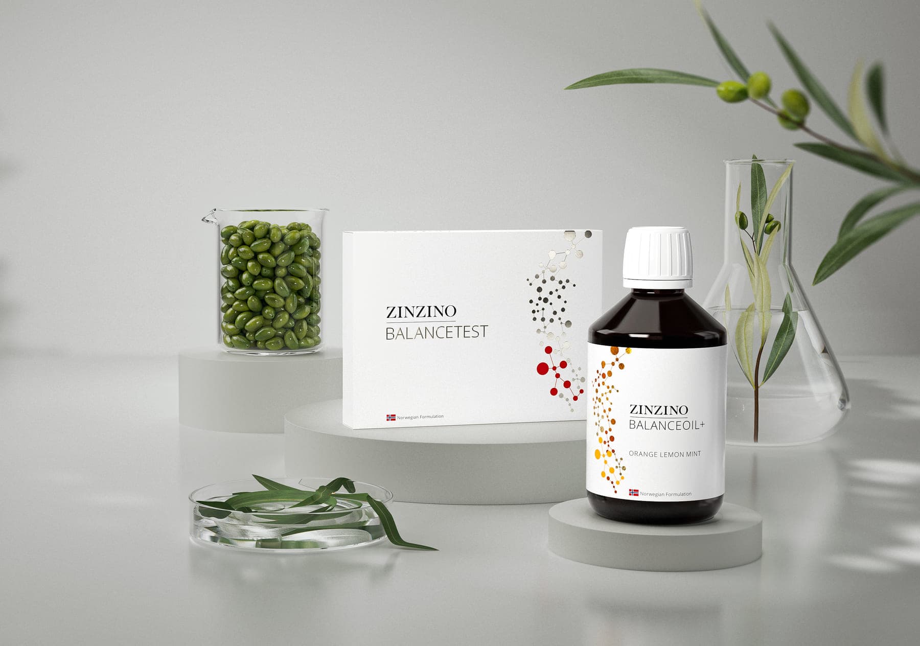 BalanceTest und BalanceOil im Studiolicht neben Olivenzweigen und Laborglas